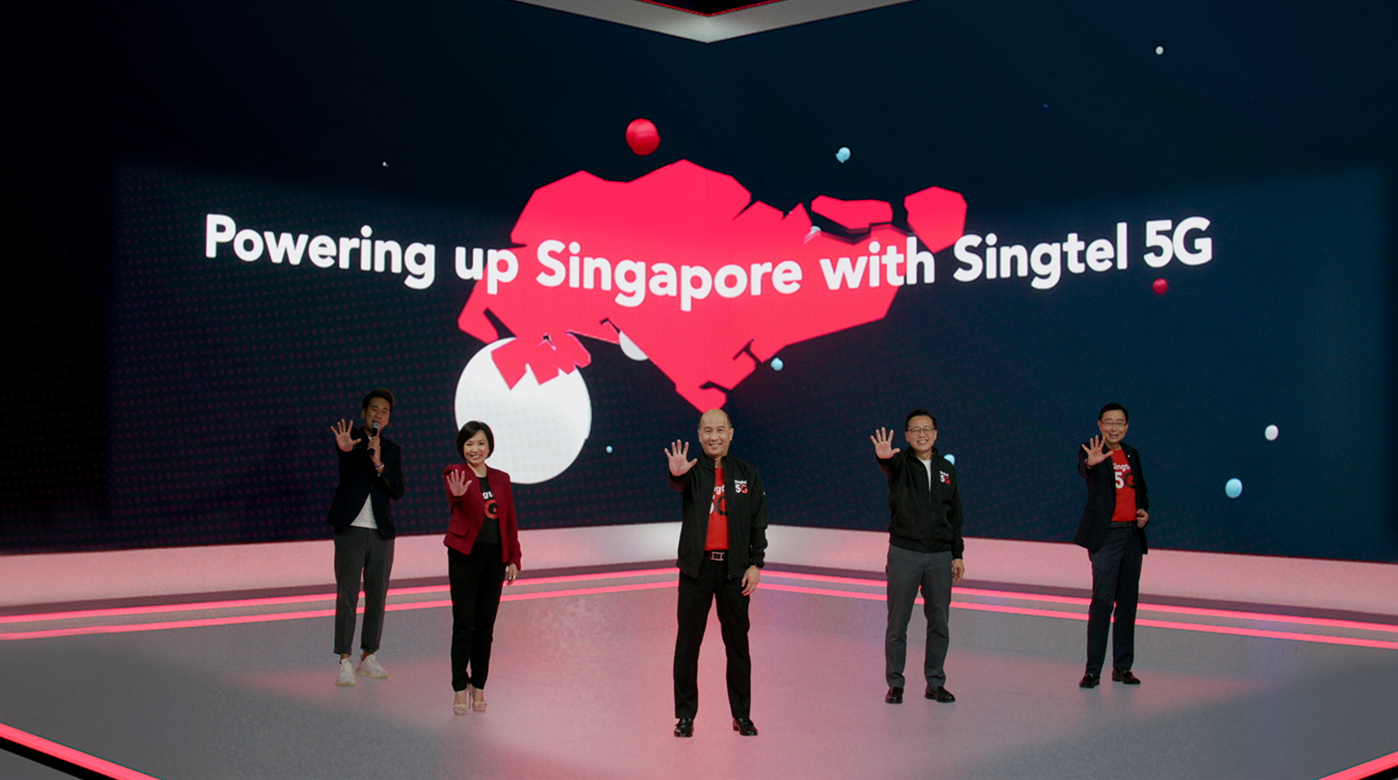 Group of Singtel representatives standing on a stage with a large screen behind them displaying “Powering up Singapore with Singtel 5G”.