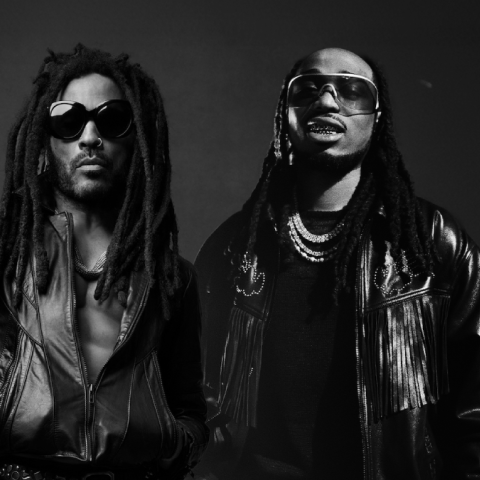 Black-and-white press image of Lenny Kravitz and Quavo posing together in leather jackets and sunglasses, photographed in a studio setting.