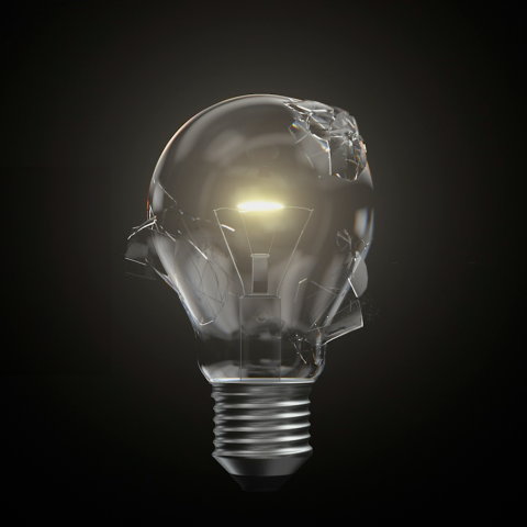 Cracked glass lightbulb with a glowing filament against a dark background, symbolising innovation and breakthrough ideas.